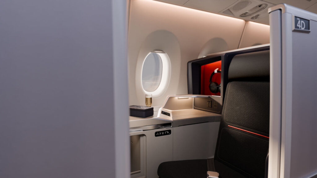 Delta One Suite with privacy door and lie-flat business class seat aboard a Delta Air Lines aircraft.