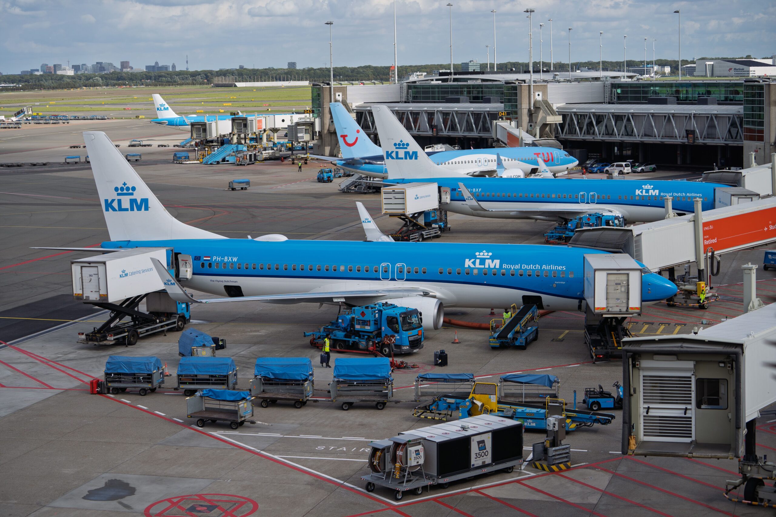 Why Do Airlines Fly with Empty Seats? KLM aircraft parked at Amsterdam Schiphol Airport, illustrating how hub airports support connecting flights and airline network planning.