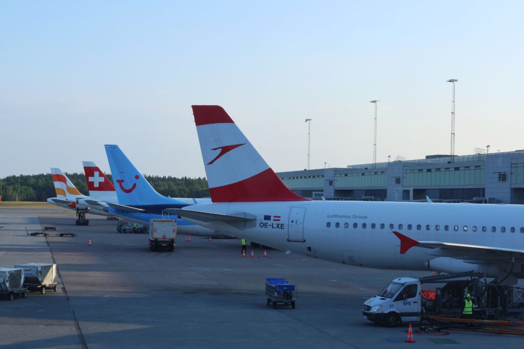 Aircraft from multiple airlines parked at airport gates, representing airline strategy, fleet planning, route networks, and competition.