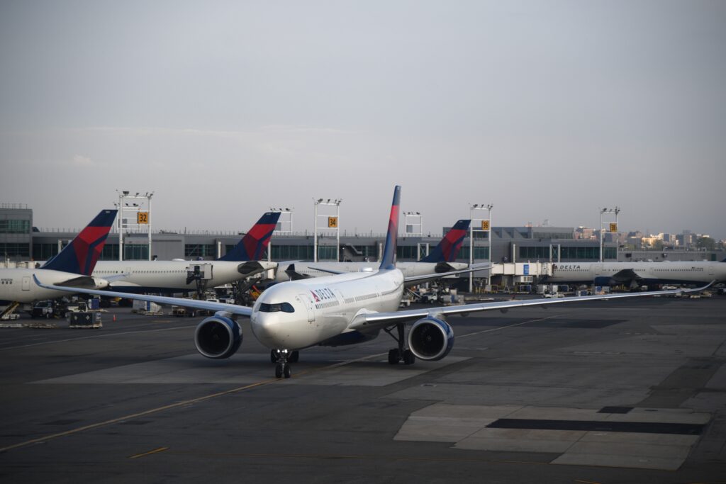 Delta Air Lines aircraft taxiing at a major airport, representing airline loyalty programs and the decision of whether buying airline miles is worth it.
