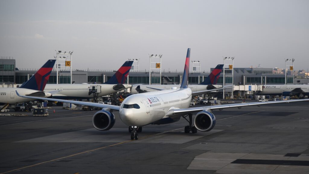 Delta Air Lines aircraft taxiing at a major airport, representing airline loyalty programs and the decision of whether buying airline miles is worth it.