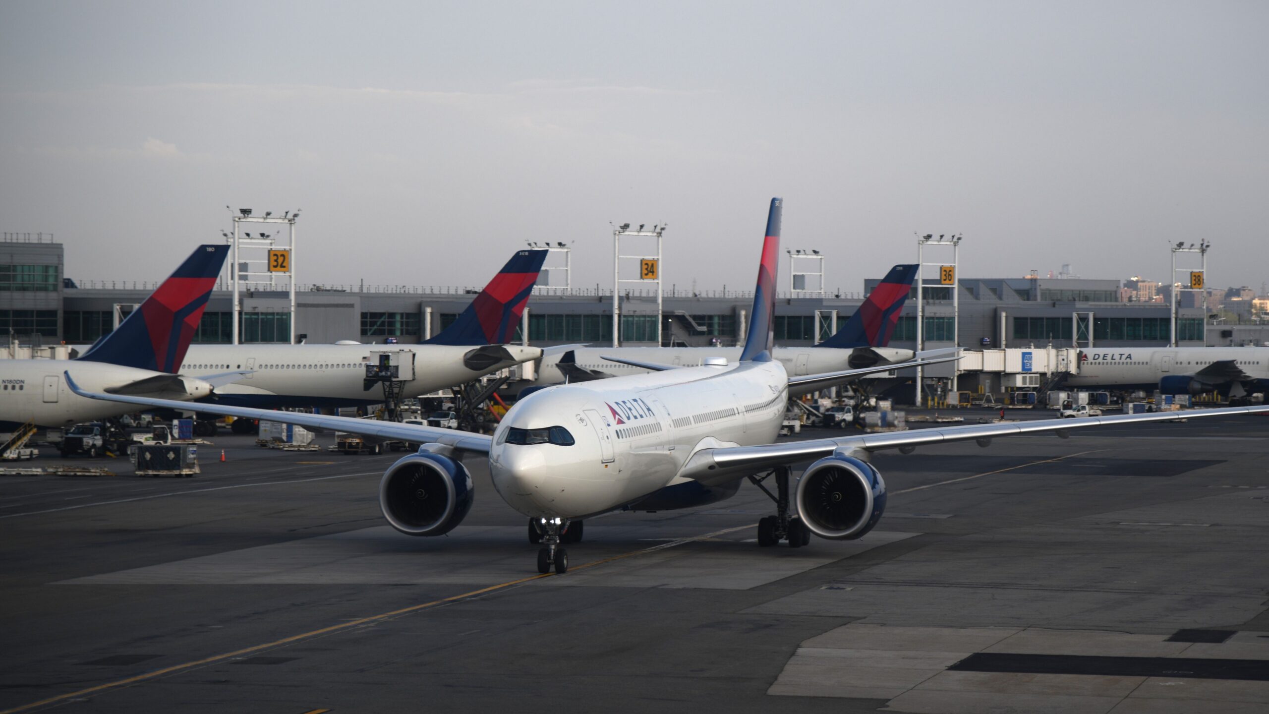 Delta Air Lines aircraft taxiing at a major airport, representing airline loyalty programs and the decision of whether buying airline miles is worth it.