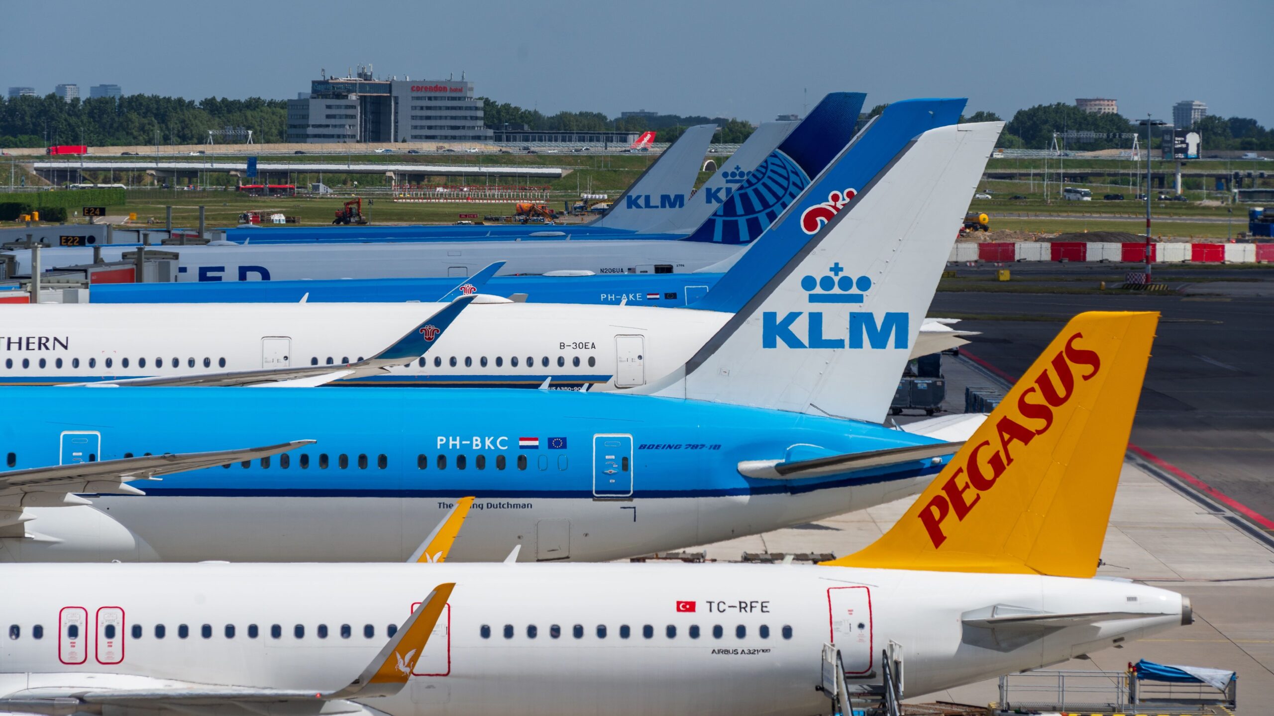 Aircraft from multiple airlines parked at airport gates, representing airline fleet planning, capacity management, and the economics behind airfare pricing.