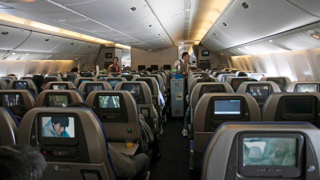 Economy class aircraft cabin showing rows of airline seats managed through revenue management