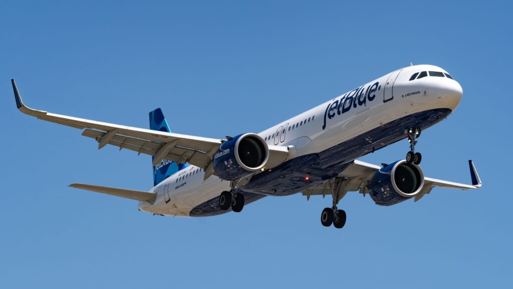 JetBlue Airbus A321 aircraft flying against a clear blue sky