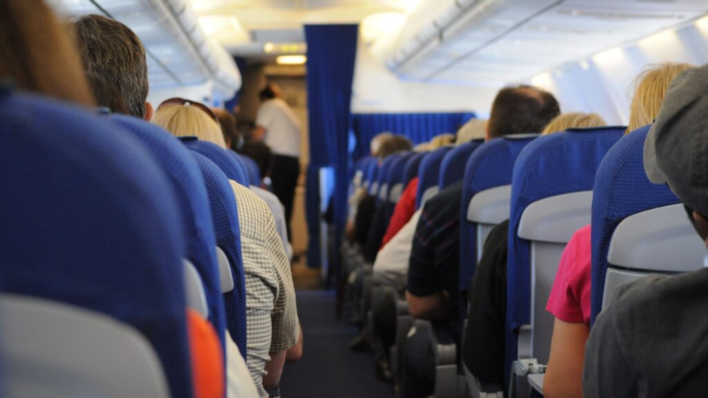 Passengers seated in an airplane cabin illustrating why airlines overbook flights