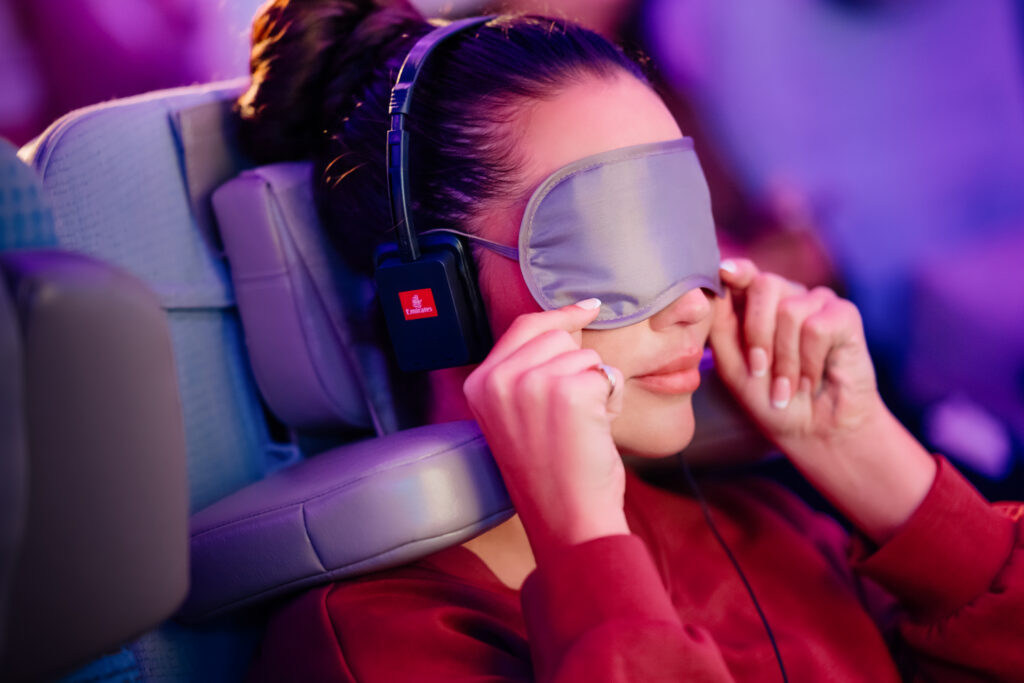 Passenger resting with Emirates U-Dream headrest in Economy Class representing the future of airline cabins